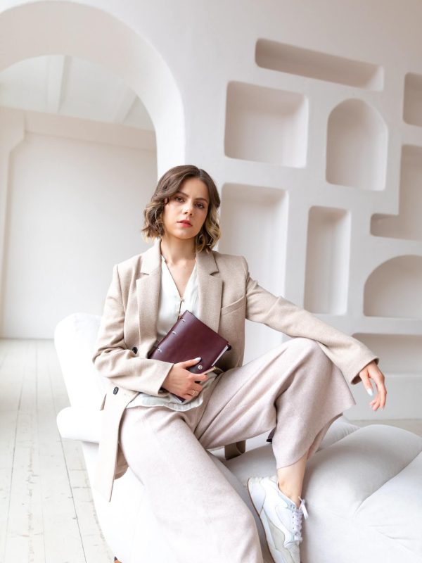 a-young-woman-coach-sits-on-the-white-armchair-with-business-dairy.jpg